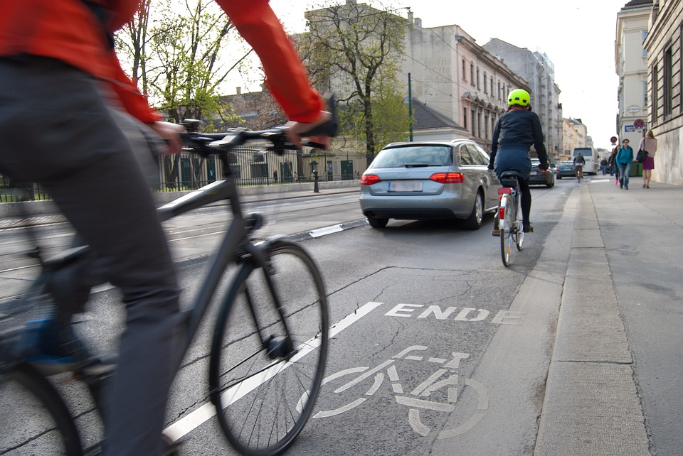 pessoas pedalando de bicicleta no trânsito da cidade