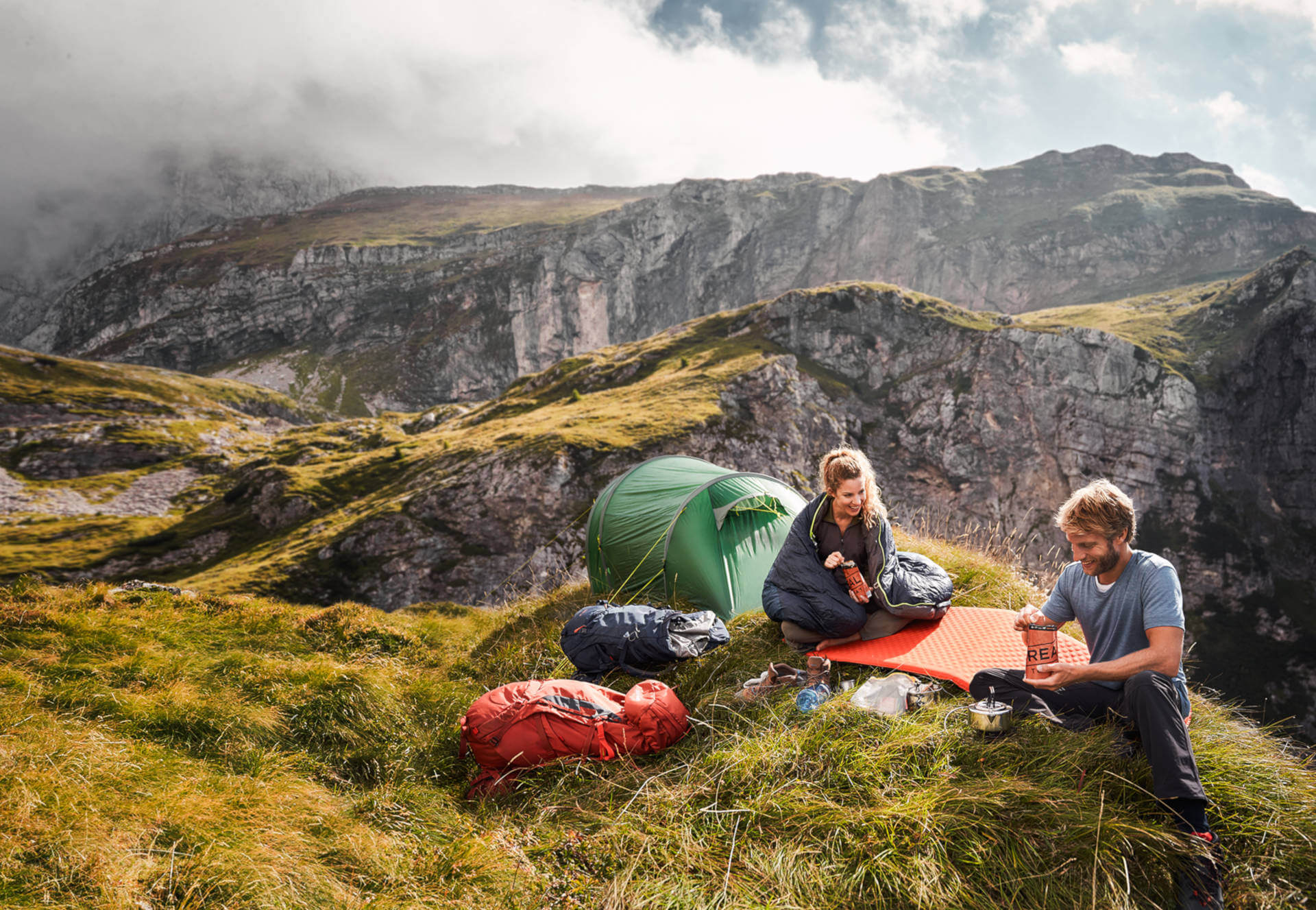 Casal partilha alimentação durante camping na montanha