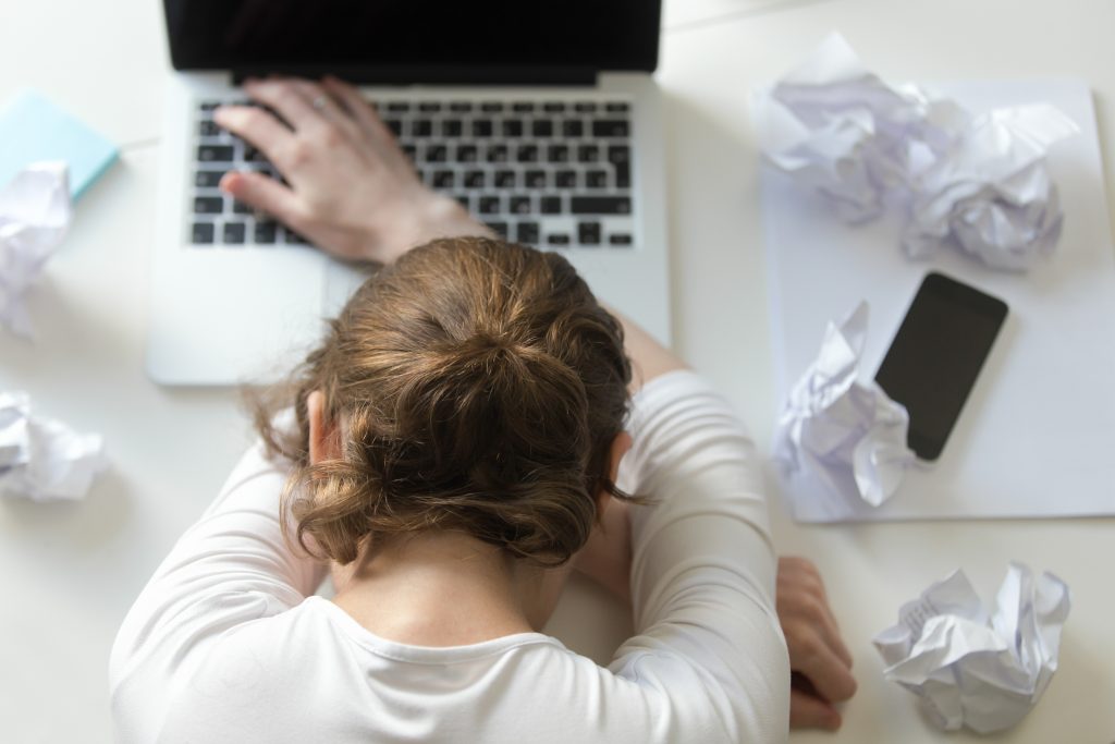 mulher frustrada com descansando a cabeça sobre o braço para se desconectar do trabalho