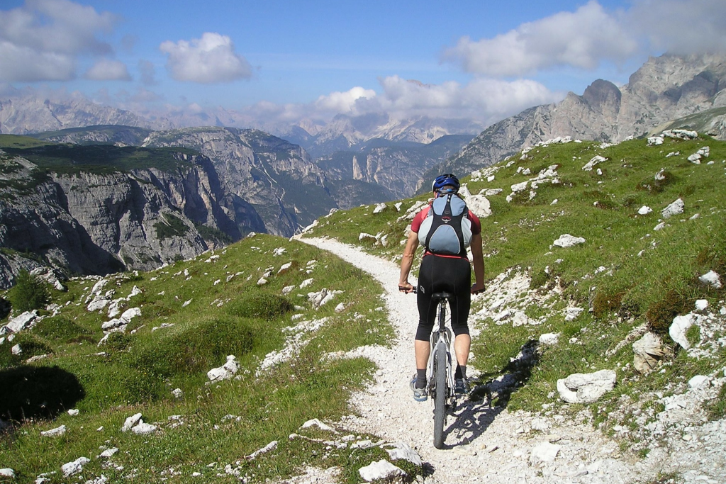Ciclista fazendo bikepacking nas montanhas com uma mochila nas costas